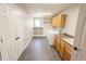 Well-lit laundry room with built-in shelving, cabinetry, washer, dryer and tile floors at 7093 Republic Ln, Indianapolis, IN 46259