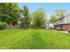 Large backyard with a lush green lawn, a trampoline, and a wooden fence for added privacy at 713 Colonial Way, Greenwood, IN 46142
