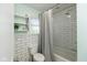 Bathroom featuring a shower with white subway tile and dark grout, plus an open shelf for decor at 713 Colonial Way, Greenwood, IN 46142