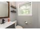 Well-lit bathroom with a modern vanity, updated fixtures, and a large window providing natural light at 713 Colonial Way, Greenwood, IN 46142