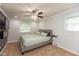 Neutral bedroom with a queen bed, ceiling fan, light gray walls, and a wall-mounted television with electric fireplace at 713 Colonial Way, Greenwood, IN 46142