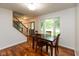 Inviting dining room with wood floors, staircase, and large window at 713 Colonial Way, Greenwood, IN 46142