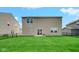 View of the rear of the home showing the well-kept lawn, patio, and neutral siding at 7226 Sayers Rd, Indianapolis, IN 46259