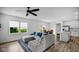Bright living room featuring a comfortable gray sectional and modern ceiling fan at 7226 Sayers Rd, Indianapolis, IN 46259