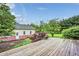 Expansive wooden deck overlooking a lush backyard with a charming garden and a separate cottage at 7333 State Road 42, Martinsville, IN 46151