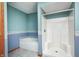 This bathroom showcases a convenient walk-in shower, a tub, and charming blue walls at 7333 State Road 42, Martinsville, IN 46151