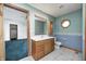 Bright bathroom featuring a vanity, toilet, large mirror and a door leading to the bedroom at 7333 State Road 42, Martinsville, IN 46151