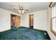 The primary bedroom features neutral walls, carpet flooring, ceiling fan, and wooden trim at 7333 State Road 42, Martinsville, IN 46151