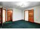 Bedroom with green carpet flooring and wood trim open to other spaces at 7333 State Road 42, Martinsville, IN 46151