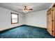 Spacious bedroom with blue carpet, ceiling fan, and a window for natural light at 7333 State Road 42, Martinsville, IN 46151