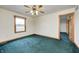 Bedroom with neutral walls, carpet flooring, ceiling fan, and wooden trim at 7333 State Road 42, Martinsville, IN 46151