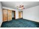 Large bedroom with green carpet, ceiling fan, and paneled doors at 7333 State Road 42, Martinsville, IN 46151
