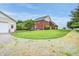 A brick two-story home with an outbuilding, surrounded by a well-manicured lawn, gravel driveway, and mature trees at 7333 State Road 42, Martinsville, IN 46151