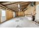Open garage featuring unfinished walls, a rolling garage door, and a side entry door to the exterior at 7333 State Road 42, Martinsville, IN 46151