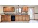 Kitchen with oak cabinets, a double sink under a window, and a black dishwasher at 7333 State Road 42, Martinsville, IN 46151