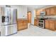 Kitchen with stainless steel refrigerator and appliances, wood cabinets, and tile floor at 7333 State Road 42, Martinsville, IN 46151