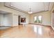 Open-concept living room showcasing hardwood floors, a modern chandelier, and large windows at 7333 State Road 42, Martinsville, IN 46151