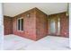Inviting covered porch featuring brick walls, a light fixture, and a beautiful wooden front door at 7333 State Road 42, Martinsville, IN 46151
