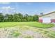 Exterior view of a detached garage with red and white siding, complemented by a lush green lawn and trees at 7333 State Road 42, Martinsville, IN 46151