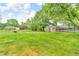 Large, fenced backyard with manicured lawn, mature trees, and storage sheds at 7633 Janean Dr, Brownsburg, IN 46112