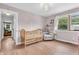 Cozy bedroom featuring a wooden crib, chair, and natural light from the window at 7633 Janean Dr, Brownsburg, IN 46112