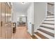 Bright entryway with hardwood floors, staircase, and view into the open-concept living area at 7633 Janean Dr, Brownsburg, IN 46112
