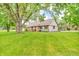 A single-story house with mixed brick and tan siding, a lush lawn, and mature trees providing shade at 7633 Janean Dr, Brownsburg, IN 46112