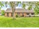 Charming brick home features a well-manicured lawn, flower boxes, and a classic front door at 7633 Janean Dr, Brownsburg, IN 46112