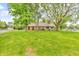 Charming single story brick home featuring a lush green lawn and mature trees in a serene setting at 7633 Janean Dr, Brownsburg, IN 46112