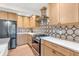Updated kitchen with stainless steel appliances, light wood cabinets, and patterned tile backsplash at 7633 Janean Dr, Brownsburg, IN 46112