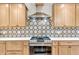Close-up view of the kitchen's stainless steel range, custom backsplash, and countertops at 7633 Janean Dr, Brownsburg, IN 46112
