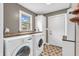 Functional laundry room with modern washer and dryer, storage, and exterior door at 7633 Janean Dr, Brownsburg, IN 46112