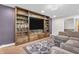Comfortable living room with custom built-in shelving, hardwood floors, and plush seating at 7633 Janean Dr, Brownsburg, IN 46112