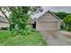 Charming single-Gathering home features a tan exterior, two-car garage, and mature trees at 7859 Chesapeake E Dr, Indianapolis, IN 46236