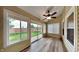 Inviting sunroom with many windows and backyard views, featuring stylish wood-look flooring and a ceiling fan at 7859 Chesapeake E Dr, Indianapolis, IN 46236
