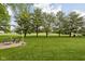 Expansive backyard featuring a fire pit and mature shade trees at 7990 S County Road 200 E, Pittsboro, IN 46167
