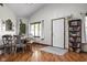 Well-lit dining area with hardwood floors, featuring a decorative bookshelf and a white front door at 7990 S County Road 200 E, Pittsboro, IN 46167
