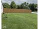 Spacious backyard featuring lush green grass and a tall wooden fence for added privacy at 8123 Summertree Ct, Indianapolis, IN 46256