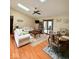 Cozy living room featuring hardwood floors, a ceiling fan, and sliding glass doors to the backyard at 8123 Summertree Ct, Indianapolis, IN 46256