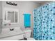Well-lit bathroom featuring a vanity with a sink, toilet, and shower with a blue curtain at 8446 S Paddleboat Ln, Pendleton, IN 46064