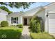 Inviting front entrance with a covered porch, black front door, and lush green landscaping at 8446 S Paddleboat Ln, Pendleton, IN 46064