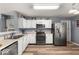 Well-lit kitchen with white cabinets, stainless steel appliances, and wood-look vinyl flooring at 8446 S Paddleboat Ln, Pendleton, IN 46064