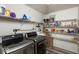 Functional laundry room with modern appliances, storage shelves, and laminate floors at 8446 S Paddleboat Ln, Pendleton, IN 46064
