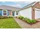Close up of home showcasing manicured landscaping, brick accents, blue shutters, and a welcoming front entrance at 8684 Captain Dr, Avon, IN 46123