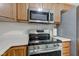 The kitchen boasts stainless steel appliances, wood cabinets, and a smooth, white countertop at 8684 Captain Dr, Avon, IN 46123
