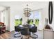 Bright dining room featuring a modern chandelier, neutral decor, and views of the backyard at 8684 Marietta Ln, McCordsville, IN 46055