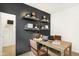 Inviting home office featuring a dark accent wall with floating shelves and a spacious desk at 8684 Marietta Ln, McCordsville, IN 46055