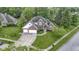 Aerial shot of a two-story brick home with a spacious lawn, attached garage, and manicured landscaping at 8723 Bergeson Dr, Indianapolis, IN 46278