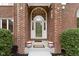 Covered front porch with decorative pots and a large arched doorway with glass paneled door at 8723 Bergeson Dr, Indianapolis, IN 46278