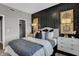 Inviting main bedroom with black paneled wall, stylish nightstands, decorative lamps, and a walk-in closet at 8838 Alexander Ridge Dr, McCordsville, IN 46055